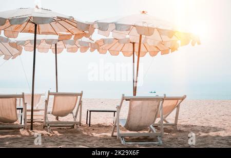 Transats et parasol blancs sur la plage tropicale. Parasol blanc sur la plage en été Banque D'Images