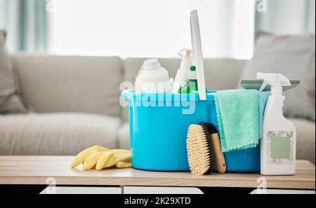 Maison, service de nettoyage et contenant avec flacon pulvérisateur, gants en caoutchouc et gommage à la maison salle de séjour ou à l'intérieur de l'appartement. Jour de nettoyage du printemps, carrière o Banque D'Images