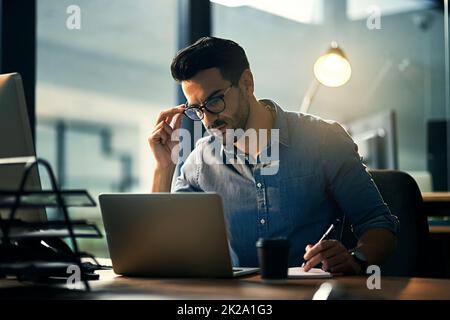 La priorité des tonights est la productivité. Prise de vue d'un jeune homme d'affaires utilisant un ordinateur portable tard dans la nuit au travail. Banque D'Images