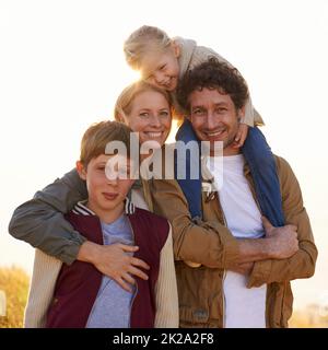 Gardez vos proches à proximité. Portrait d'une famille heureuse sur une promenade matinale ensemble. Banque D'Images