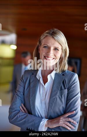 Shes en charge. Photo d'une femme d'affaires confiante debout devant son équipe au bureau. Banque D'Images