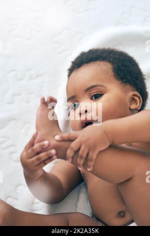 Regardez ce que je peux faire. Photo d'une adorable petite fille à la maison. Banque D'Images