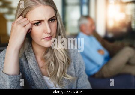 Theres un mur entre leur mariage. Coupe courte d'une femme qui a l'air découragée après avoir eu un combat avec son mari à la maison. Banque D'Images