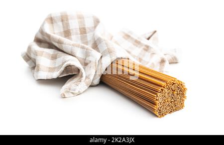 Spaghetti de grains entiers non cuits. Pâtes brutes isolées sur fond blanc. Banque D'Images