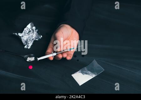 Addict homme avec la seringue utilisant des drogues. Banque D'Images