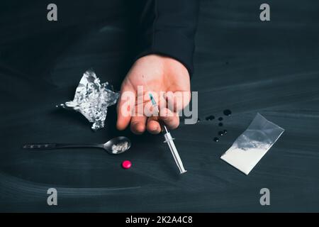 Addict homme avec la seringue utilisant des drogues. Banque D'Images