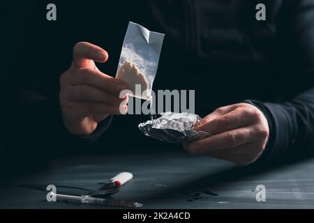 Un drogué ou un trafiquant de drogue prépare de l'héroïne. Banque D'Images