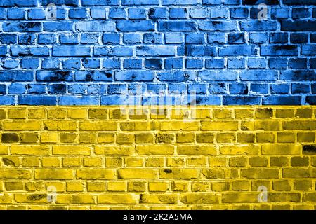 Drapeau national de l'Ukraine peint sur un mur de briques. Bannière sur l'arrière-plan du mur de briques ancien en bleu et jaune craquelé. Le concept des relations entre les pays - pas de guerre entre l'Ukraine et la Russie. Banque D'Images