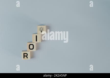 Cubes en bois avec le symbole de retour sur investissement ROI sur l'arrière-plan et l'espace de copie.concepts d'affaires. Banque D'Images