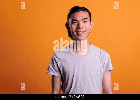 Jeune homme souriant souriant asiatique portrait, adolescent homme regardant l'appareil photo, vue de face. Adolescent joyeux avec l'expression faciale positive et le sourire, belle photo photogénique personne moyen Banque D'Images