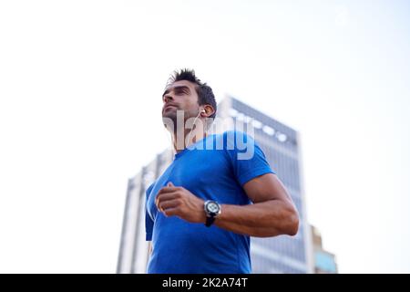 En déplacement dans la ville. Photo d'un jeune homme qui fait du jogging dans la ville. Banque D'Images