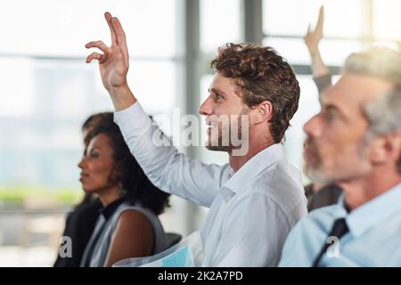 C'est la partie question et réponse. Photo courte d'un beau jeune homme d'affaires levant la main au cours d'un séminaire. Banque D'Images