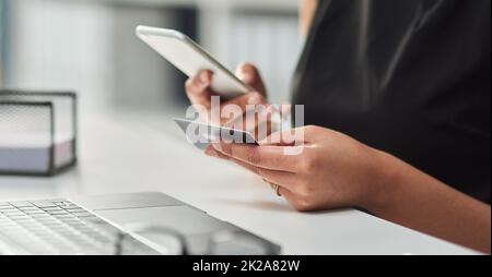 La finance d'entreprise devient toujours plus intelligente. Photo rognée d'une femme d'affaires non reconnaissable effectuant un paiement par carte de crédit à l'aide d'un téléphone portable. Banque D'Images