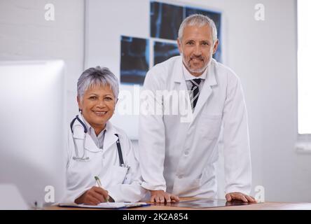 Consulter un collègue pour une deuxième opinion. Photo de deux médecins travaillant ensemble dans un hôpital. Banque D'Images