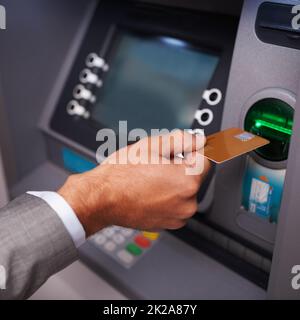 Besoin d'argent. Photo rognée d'un homme d'affaires en insérant sa carte bancaire dans un guichet automatique. Banque D'Images