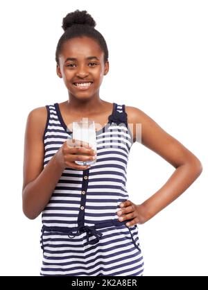 Le lait va m'aider à grandir. Portrait studio d'une jeune fille afro-américaine qui boit un verre de lait isolé sur blanc. Banque D'Images