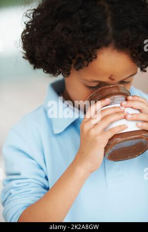 Un régal pour le tounge. Un petit garçon mangeant Nutella dans un pot. Banque D'Images