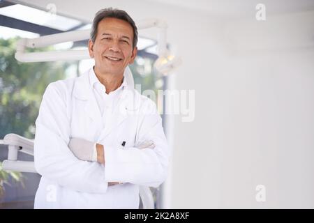 Prêt pour la chaise. Portrait d'un chirurgien dentaire homme mature debout dans son bureau. Banque D'Images