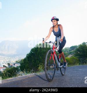 Profitez de la vue depuis le sommet. Photo d'un cycliste solitaire sur une route rurale avec espace de copie. Banque D'Images