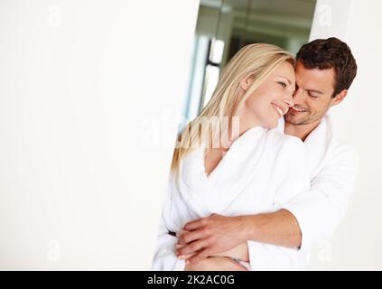 Bonjour. Un jeune couple aimant dans des peignoirs de détente à la maison. Banque D'Images