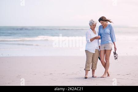 Découvertes avec ma fille. Photo d'une mère âgée et de sa fille adulte explorant la plage. Banque D'Images