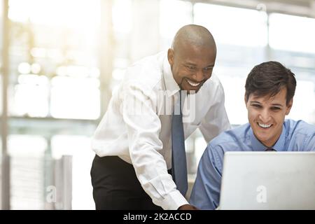 C'est un excellent travail. Une courte photo de deux hommes d'affaires discutant du travail au bureau. Banque D'Images