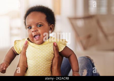 Shes un petit miracle précieux. Prise de vue d'une petite fille qui a l'air heureuse alors que sa mère la tient. Banque D'Images