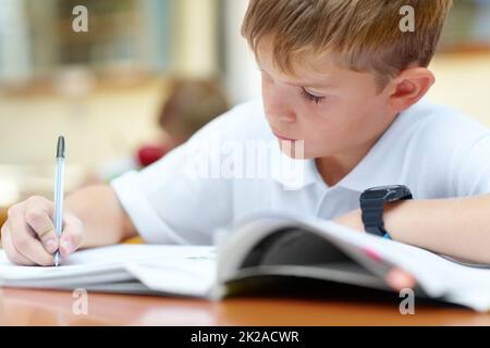 HES s'assure que tout son travail est fait. Deux jeunes élèves font leur travail scolaire en classe. Banque D'Images