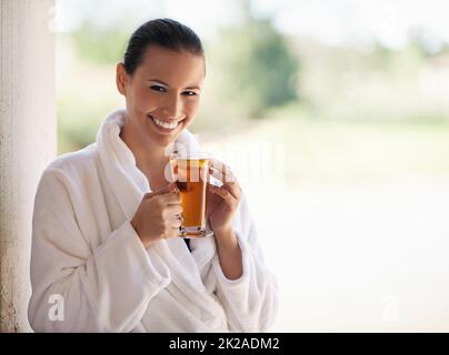 Le seul endroit où je dois être en ce moment. Photo d'une jeune femme qui boit un thé glacé au spa. Banque D'Images