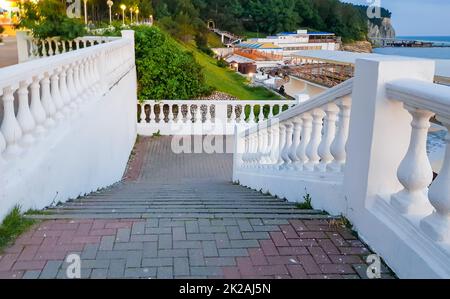 Balustrade blanche classique le long des marches menant à la mer, un escalier avec une balustrade blanche avec un paysage marin en été, à l'extérieur Banque D'Images