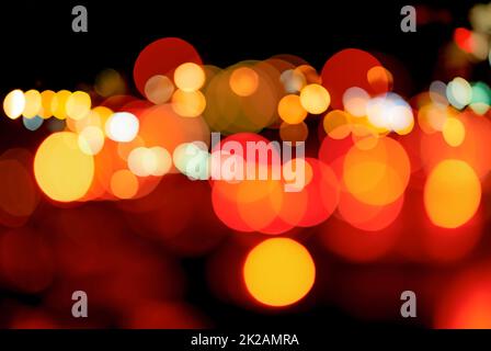 Arrière-plan bokeh rouge et orange flou. Arrière-plan abstrait flou de la lumière urbaine. Lumière chaude avec superbe motif de bokeh rond. Lumière la nuit. Les feux de rue s'allument dans la ville la nuit tombée. Banque D'Images