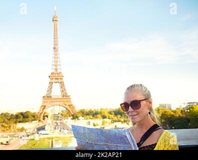 Cette carte est très précise. Une jolie jeune femme tenant une carte tout en admirant la vue à Paris. Banque D'Images