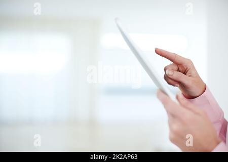 En contact avec le monde de l'entreprise. Prise de vue rognée d'une femme d'affaires touchant l'écran d'une tablette numérique. Banque D'Images