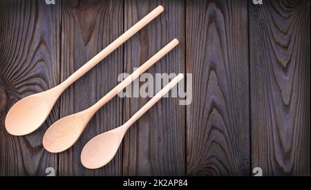 trois cuillères en bois sur une table en bois sombre avec espace pour les copies Banque D'Images