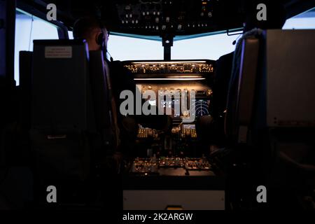 Diverse team of captain and pilot pushing engine throttle lever to takeoff with airplane from aviation cockpit. Aircrew men flying plane jet using dashboard and control panel command. Stock Photo