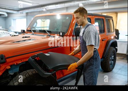 Technicien travaillant sur le réglage de la voiture dans le garage Banque D'Images