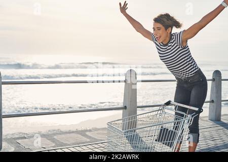 Je viens de vivre ma meilleure vie. Photo d'une jeune femme à bord d'une voiturette sur la promenade. Banque D'Images