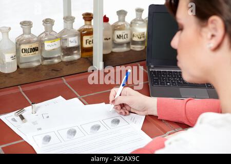 C'est un match. Photo d'un scientifique médico-légal rédigeant un rapport balistique. Banque D'Images