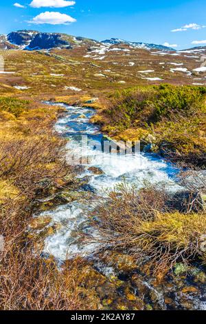 Rivière et chalets huts lac Vavatn panorama paysage Hemsedal Norvège. Banque D'Images