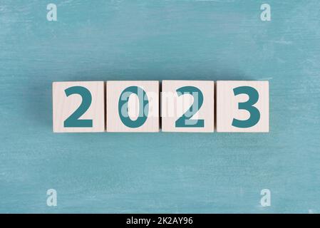 La nouvelle année 2023 est sur fond bleu, barre de chargement avec des cubes en bois, date calendrier Banque D'Images