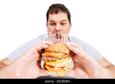 J'entre dans mon ventre, hamburger. Un jeune homme obèse sur le point de manger un énorme hamburger. Banque D'Images