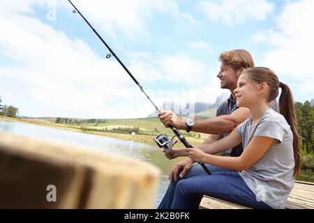 Shes déjà un pêcheur expert. Photo d'un père montrant à sa fille comment pêcher. Banque D'Images