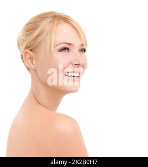 Beauté en regardant sur son épaule. Photo en studio d'une belle jeune femme avec une peau rayonnante isolée sur blanc. Banque D'Images