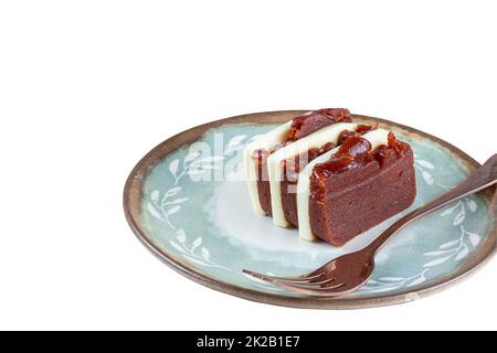 Closeup of slices of guava sweet and curd cheese next to a copper fork white background. Stock Photo