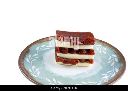 Slices of guava sweet and curd cheese stacked on a plate white background. Stock Photo