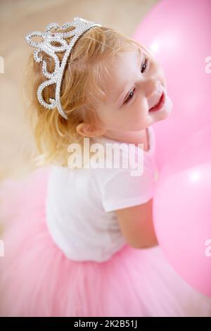 Shes la princesse d'anniversaire. Une petite fille habillée comme une princesse à sa fête d'anniversaire. Banque D'Images