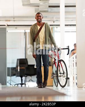 Faire les livraisons de jours. Prise de vue en longueur d'un beau messager de vélo dans un bureau. Banque D'Images