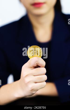 Gros plan femme d'affaires tenant quelques morceaux de jeton Bitcoin doré Banque D'Images