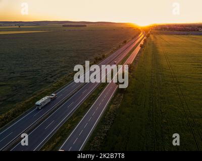 Voitures sur la route au coucher du soleil. Voiture. Voyage. Trajet sur route. Location de voiture. Banque D'Images