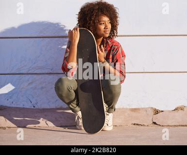 Pourquoi marcher quand vous pouvez skate. Photo d'une jeune femme sur le skateboard dans la ville. Banque D'Images